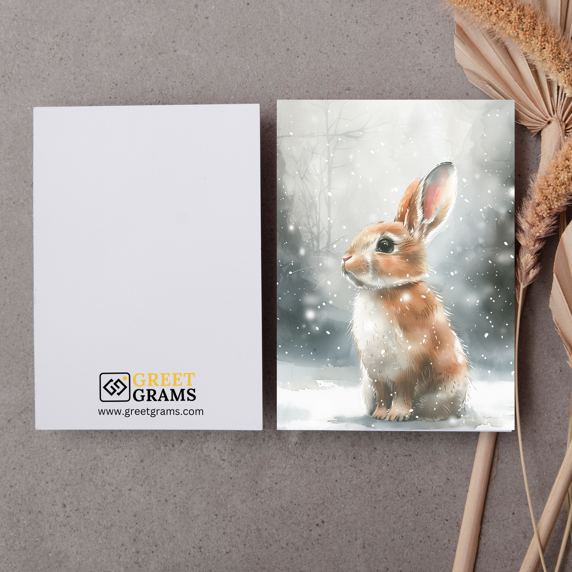 greeting card of a bunny enjoying the snowy landscape in the grey background