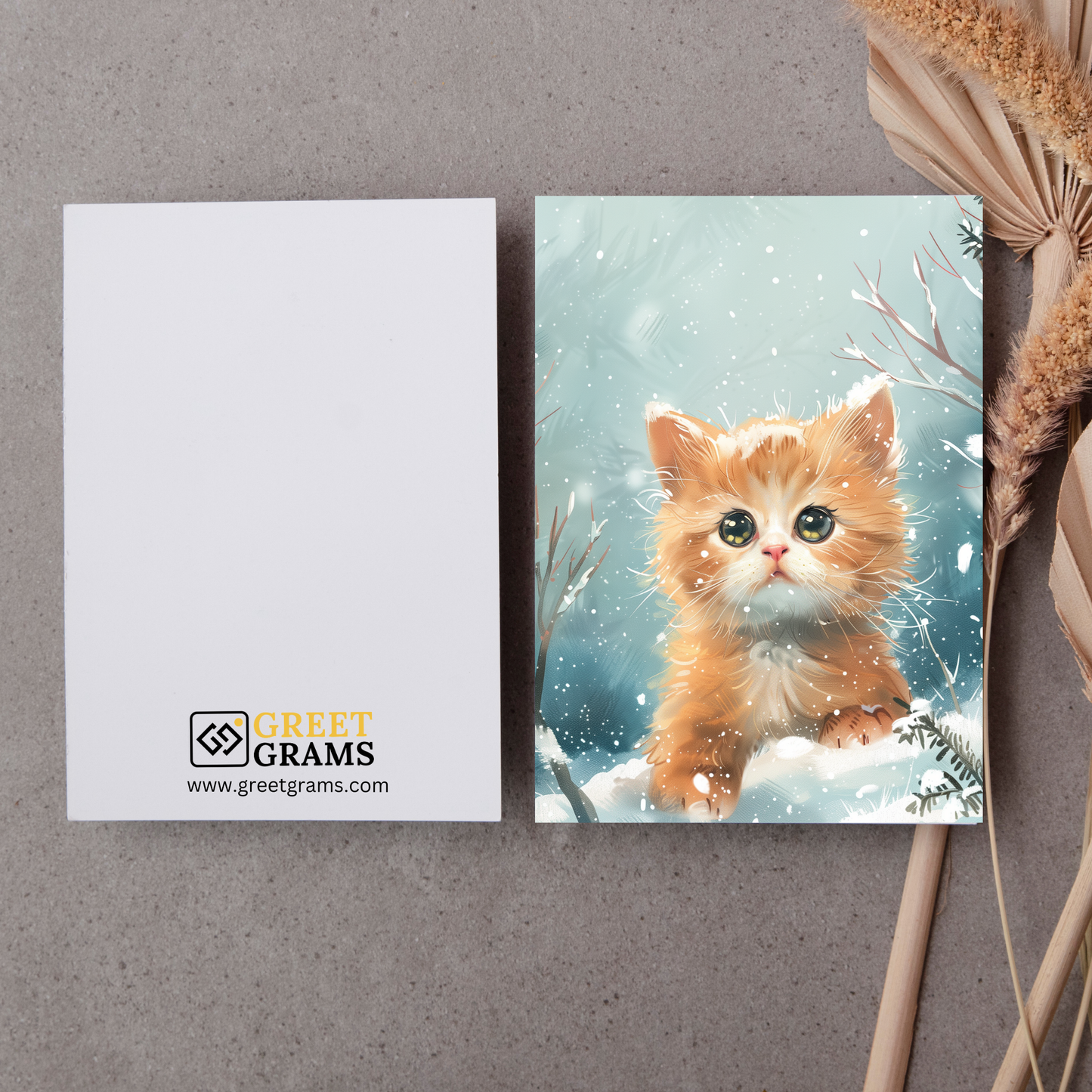 greeting card of a  Kitten playing in a winter wonderland in the grey background